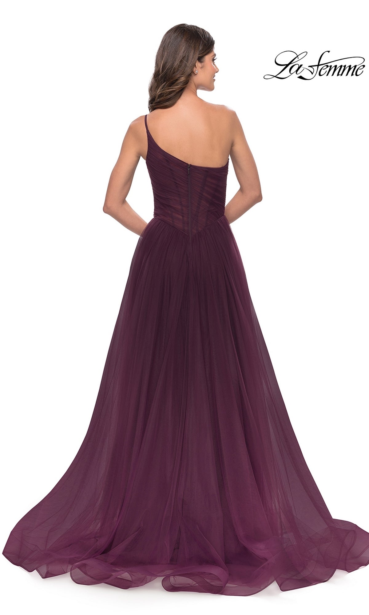 Woman in a dark purple One-Shoulder Sheer-Bodice Prom Ball Gown 31069 by La Femme, with a fitted bodice, tulle skirt, flowing train, and shown from the back.